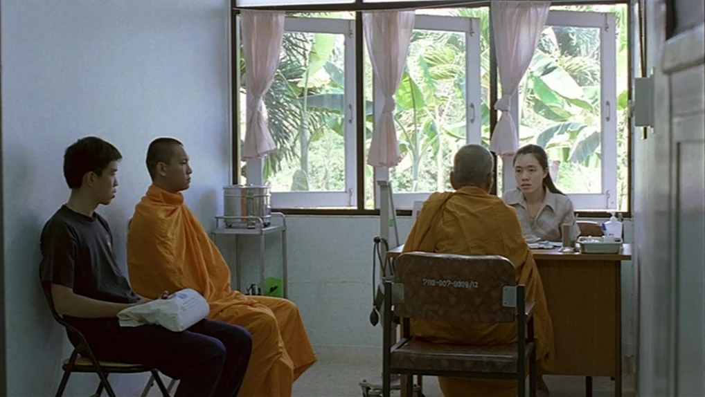 Syndromes and a Century (2006) movie still: medium — A medical exam room features white walls and windows looking out onto green foliage. A female…