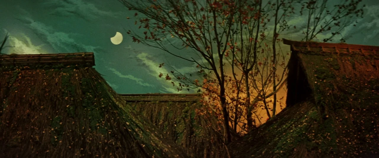 Ballad Of Narayama (1958) movie still: establishing — Several thatched roofs covered in moss are viewed from a low perspective. A bare tree with…