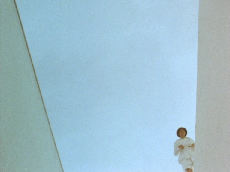 Our Lady of the Turks (1968) movie still: wide — The frame shows a bright sky visible between two sharp, angular white architectural walls. A…