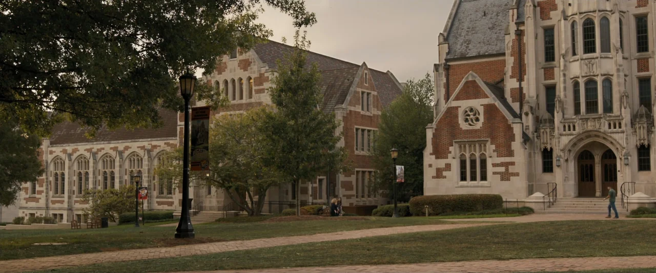 Life of the Party (2018) movie still: establishing — Gothic revival brick architecture sits on a grassy university quad during the day. A solitary…