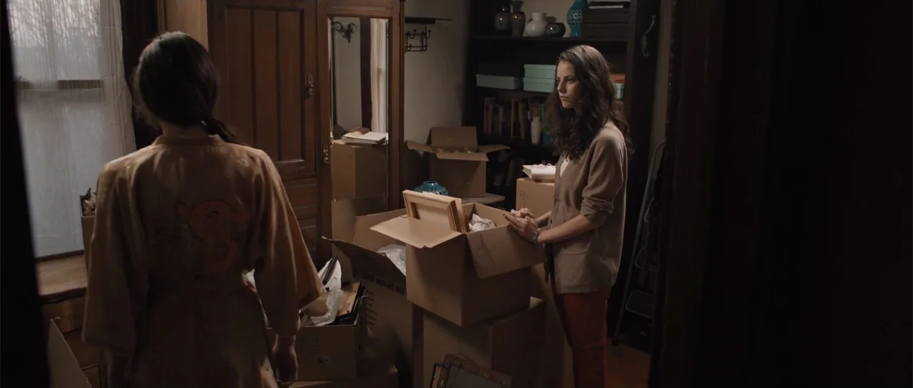The Truth About Emanuel (2013) movie still: medium — A cluttered interior space features wooden furniture and multiple cardboard boxes filled with…