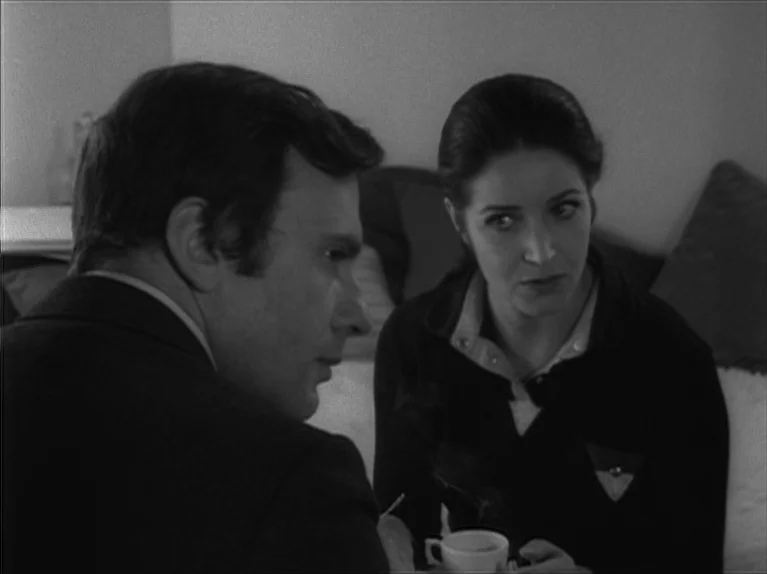 My Night At Maud’s (Ma Nuit Chez Maud) (1969) movie still: medium — A man and woman sit in a plain room with soft wall textures. They are positioned…