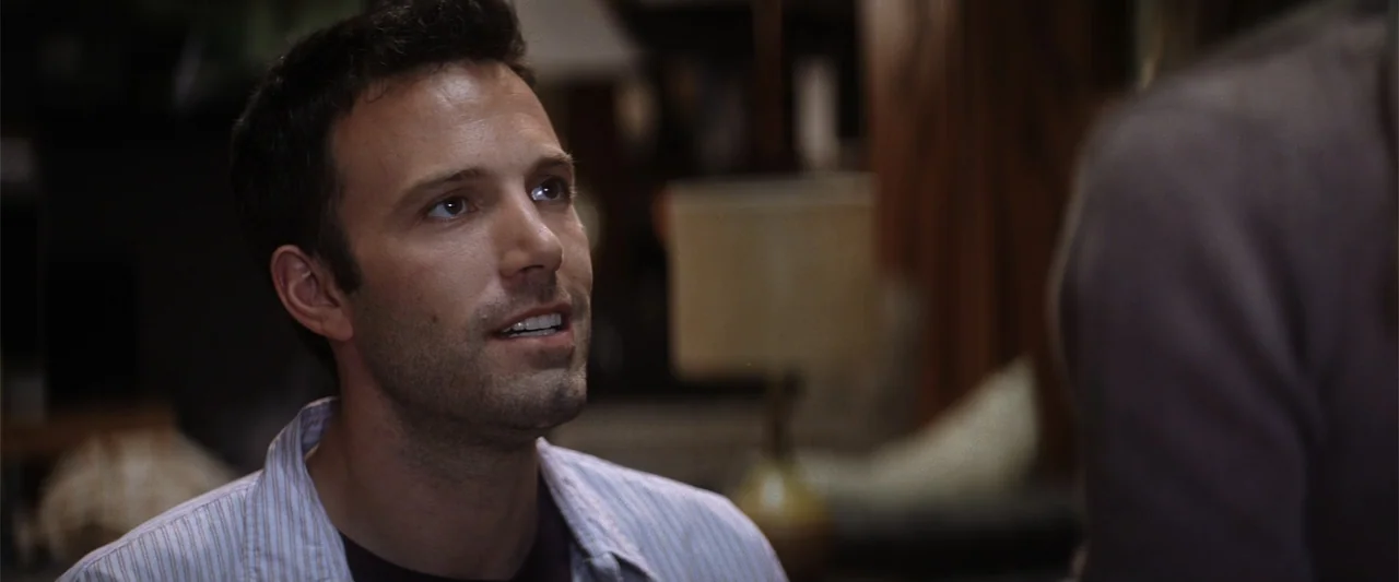 He's Just Not That Into You (2009) movie still: closeup — A dimly lit indoor space features a desk lamp in the background out of focus. A man with…