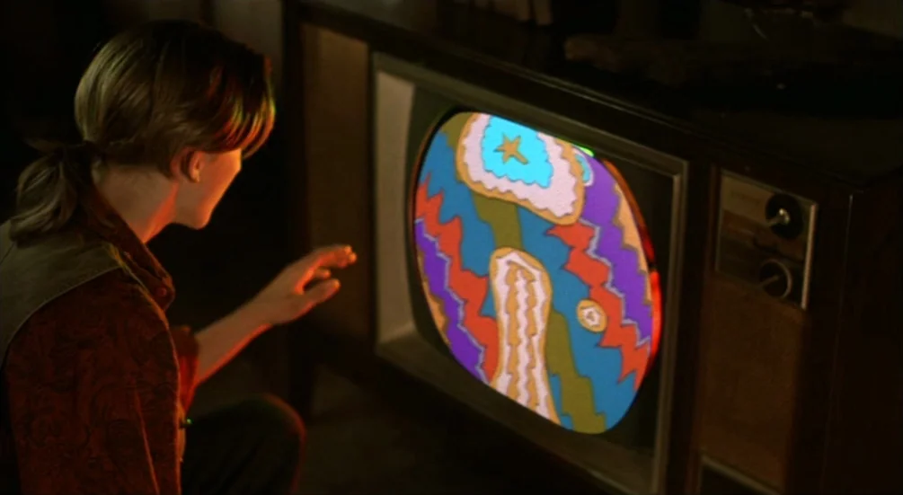 Freddy’s Dead: The Final Nightmare (1991) movie still: medium — A woman sits in a dim room before a vintage wood-paneled television set. She reaches…