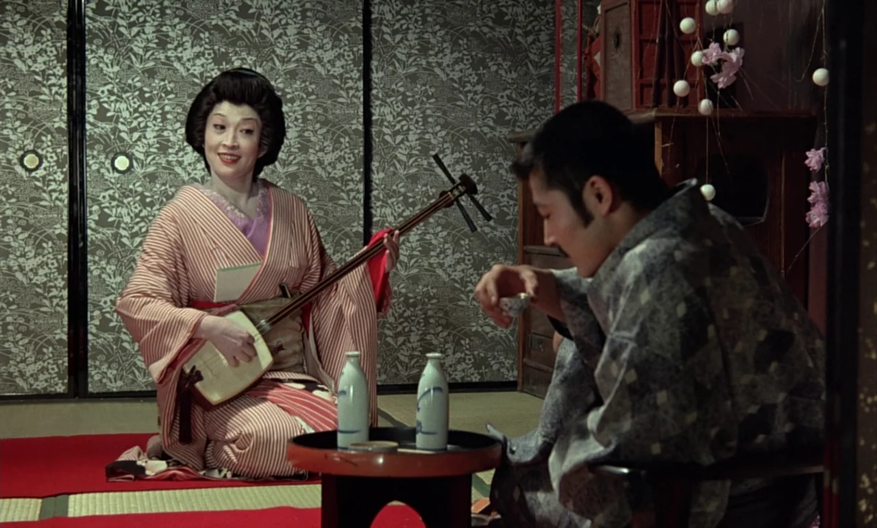 In The Realm of the Senses (1976) movie still: medium — A traditional Japanese room features patterned sliding screens and tatami mats with a red…
