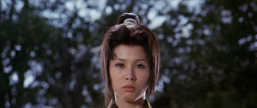 Lone Wolf and Cub: White Heaven in Hell (1974) movie still: closeup — A dense forest environment with out-of-focus green trees forming a background.…