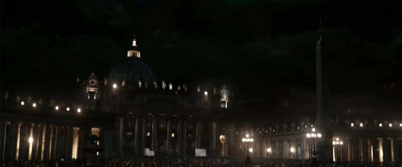 Angels & Demons (2009) movie still: establishing — The facade and dome of St. Peter's Basilica at night with the Egyptian obelisk visible. A dense…