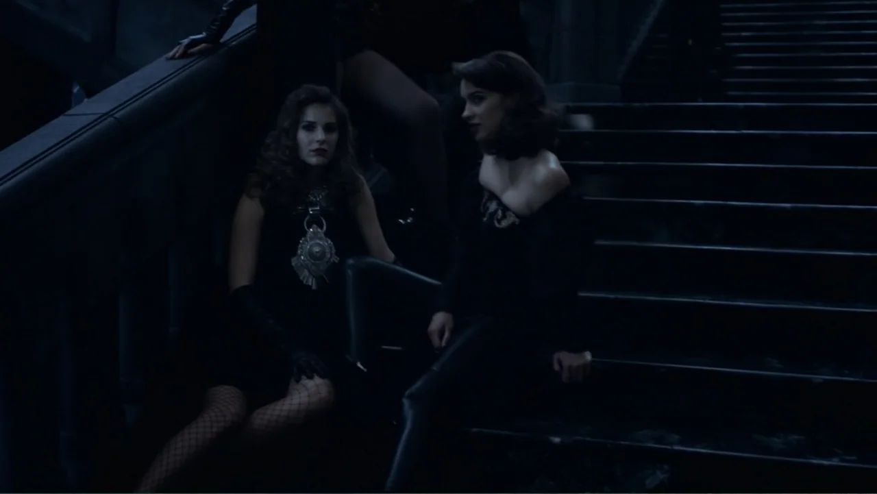 Underworld: Blood Wars (2016) movie still: medium — Two women sit on a darkened stone staircase in a dimly lit setting. They wear dark clothing and…