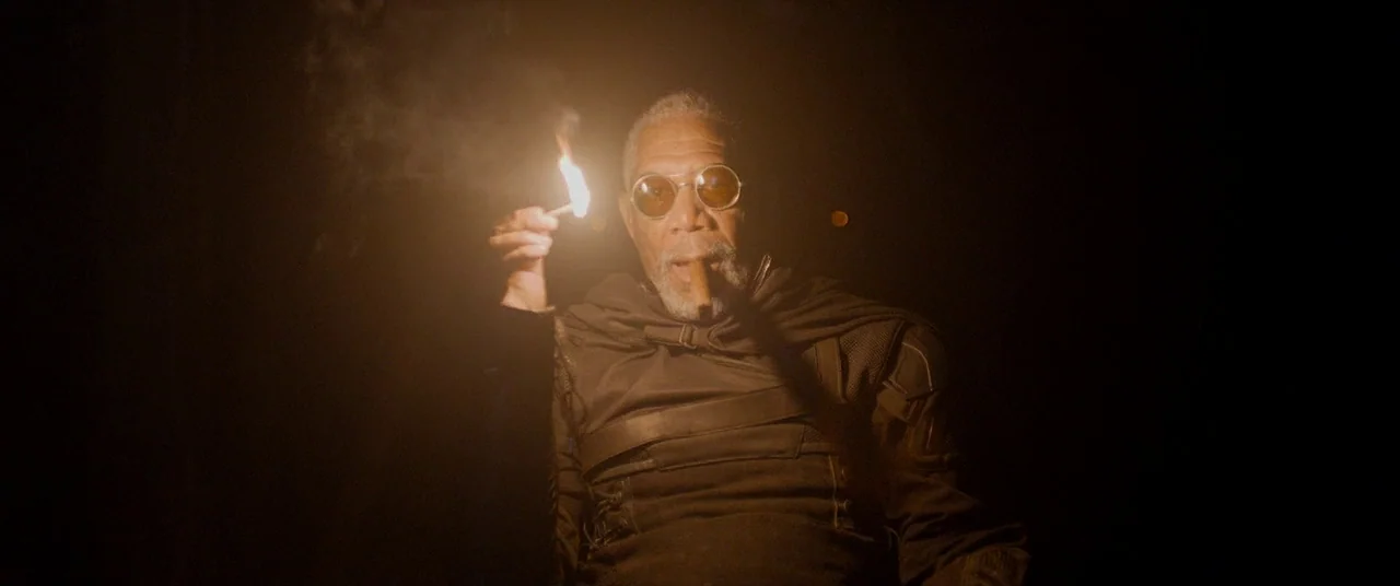 Oblivion (2013) movie still: medium — A dark, featureless environment surrounds a man illuminated by a small flickering flame. He holds a burning…