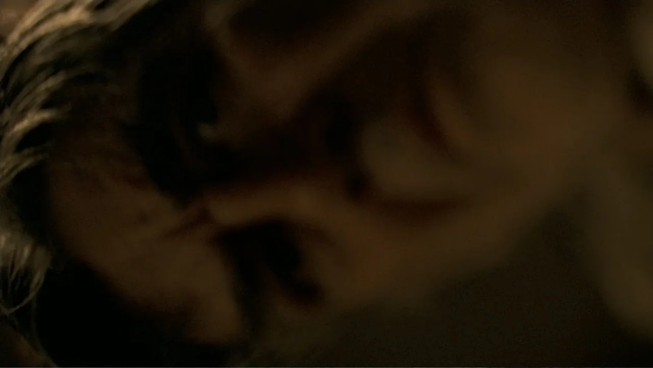 The Texas Chainsaw Massacre: The Beginning (2006) movie still: closeup — An interior space is cast in extreme darkness and shadow. A person is lying…