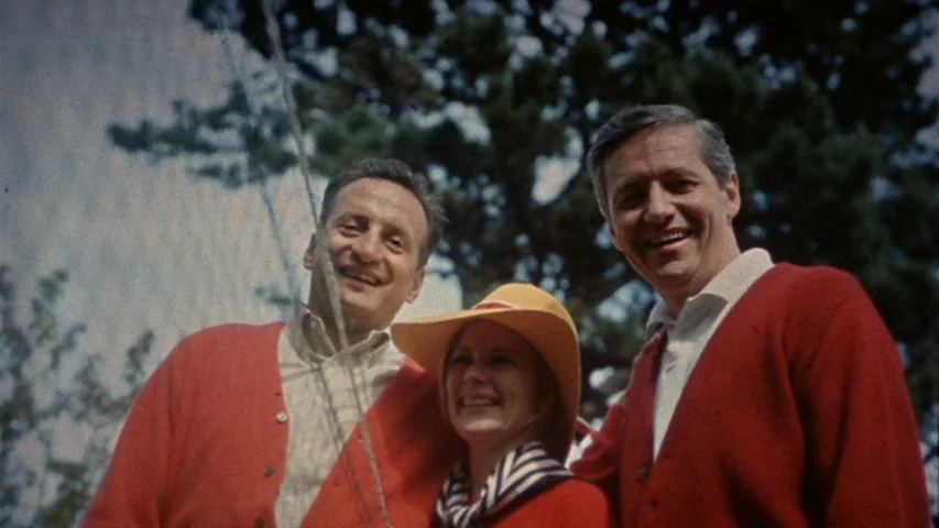 Petulia (1968) movie still: medium — Three people stand closely together in an outdoor setting with tall trees behind them. They smile directly at…