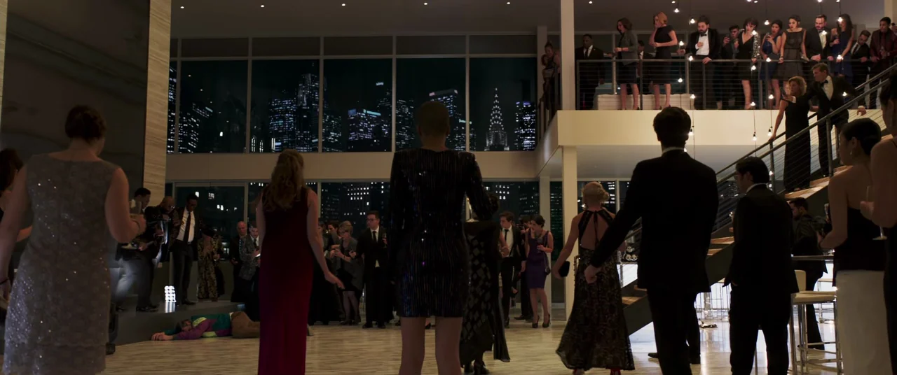 Long Shot (2019) movie still: wide — A spacious modern penthouse features floor-to-ceiling windows overlooking a nighttime city skyline. Numerous…