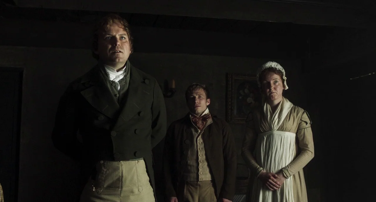 Peterloo (2018) movie still: medium — A dimly lit room with wood-paneled walls and a small framed painting on the wall. Three people in Regency-era…