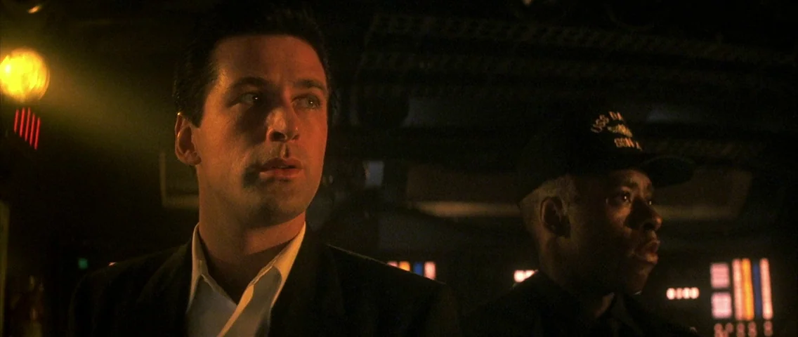 The Hunt for Red October (1990) movie still: medium — A dark, cramped space filled with glowing electronic console lights and industrial equipment.…