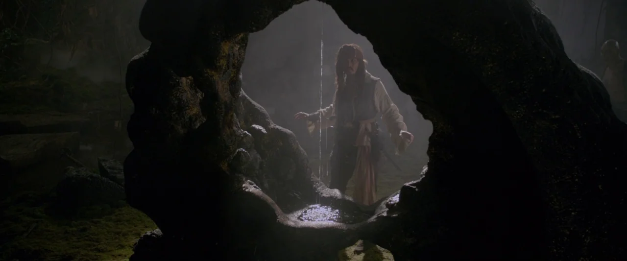 Pirates of the Caribbean: On Stranger Tides movie still: medium — A dark cave interior features a prominent, circular natural rock framing a person.…