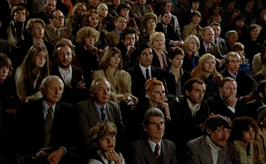 My American Uncle (Mon oncle d’Amérique) (1980) movie still: wide — A dense, multi-row audience fills a theater seating area in 1970s attire.…