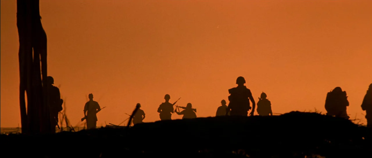 Born On The Fourth of July (1989) movie still: wide — A group of soldiers move across a field during a sunset. Dark silhouettes of the infantrymen…