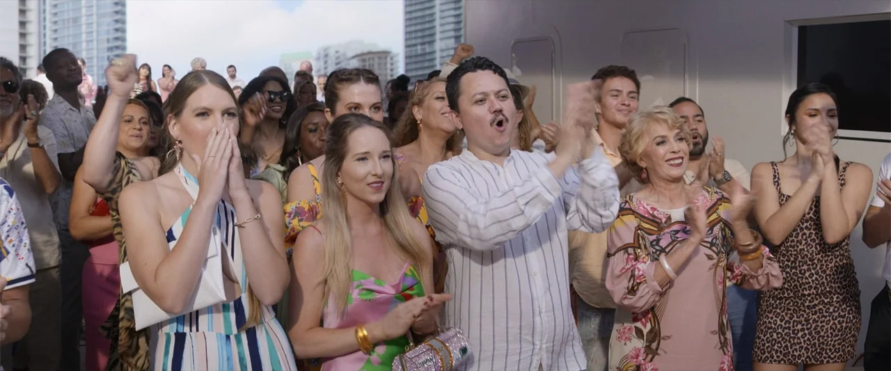 Father of the Bride (1991) movie still: medium — An outdoor deck filled with a diverse crowd of people celebrating under bright daylight. A group of…