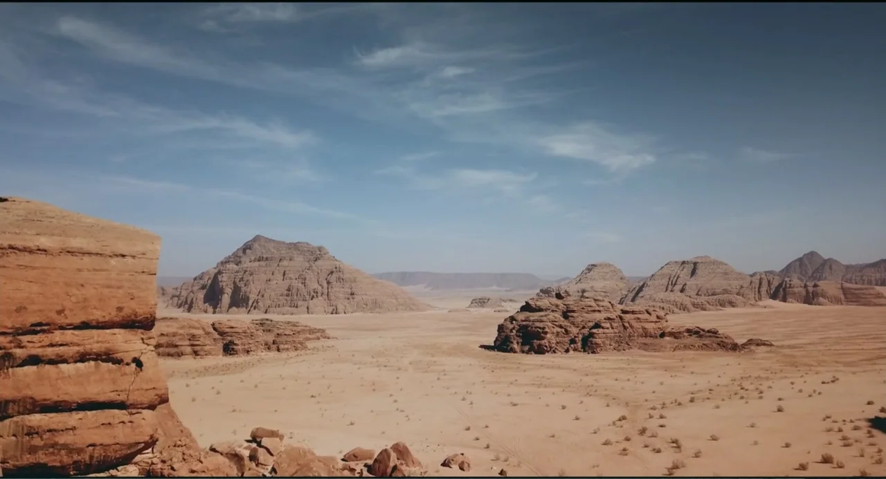 Crooked Trees Gon Give Me Wings (2022) movie still: establishing — A vast desert landscape features large sandstone rock formations under a bright…