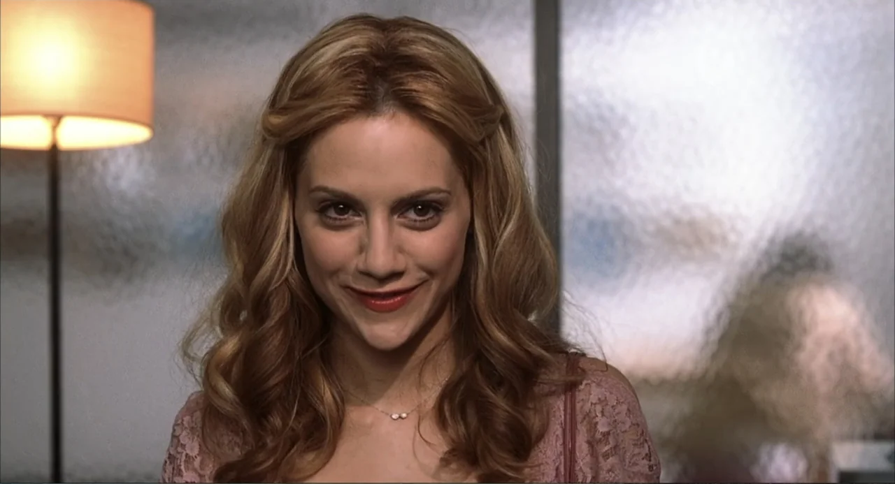 Uptown Girls (2003) movie still: closeup — An interior space with a blurred, light-colored privacy screen visible in the background. A young woman…