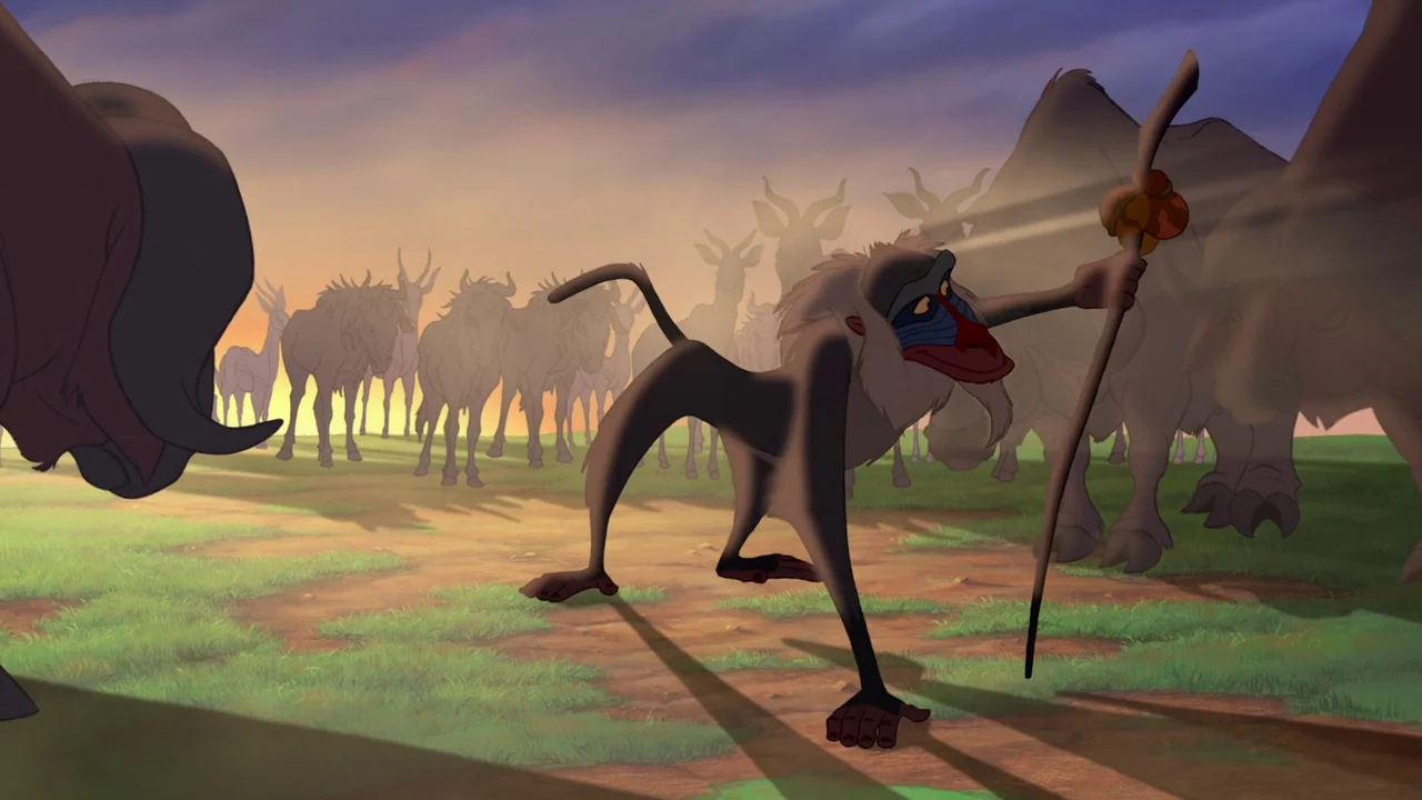 The Lion King (1994) movie still: fullbody — A vast, open grassy plain under a sunrise sky filled with silhouette animal herds. A mandrill standing…