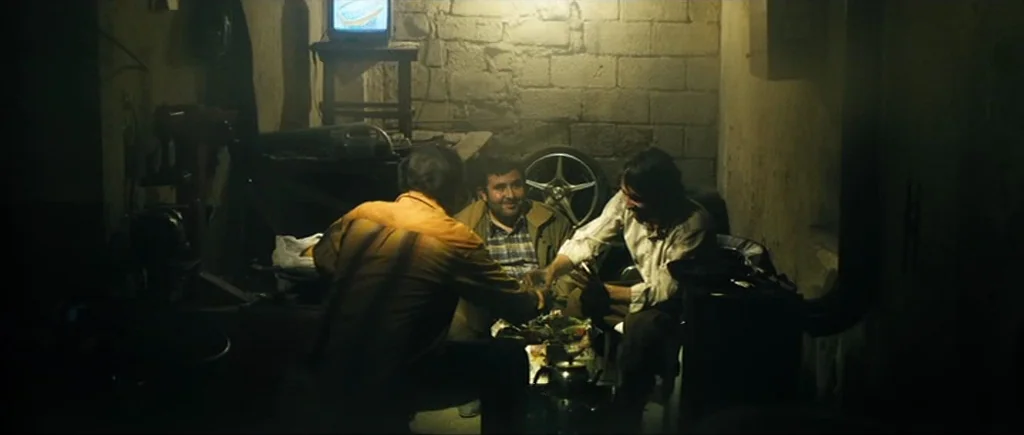 Once Upon a Time in Anatolia (2011) movie still: medium — A dark, cramped basement room features unpainted cinder block walls and industrial…