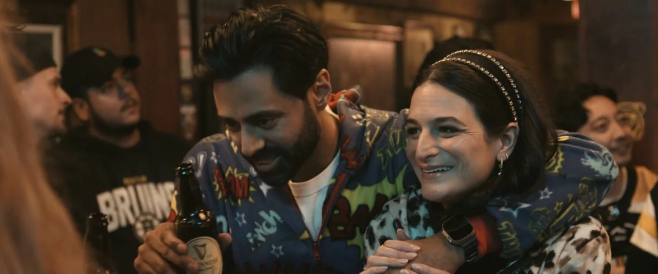 It Ends with Us (2024) movie still: medium — A crowded bar interior with blurred patrons visible in the dimly lit background. A man and a woman…