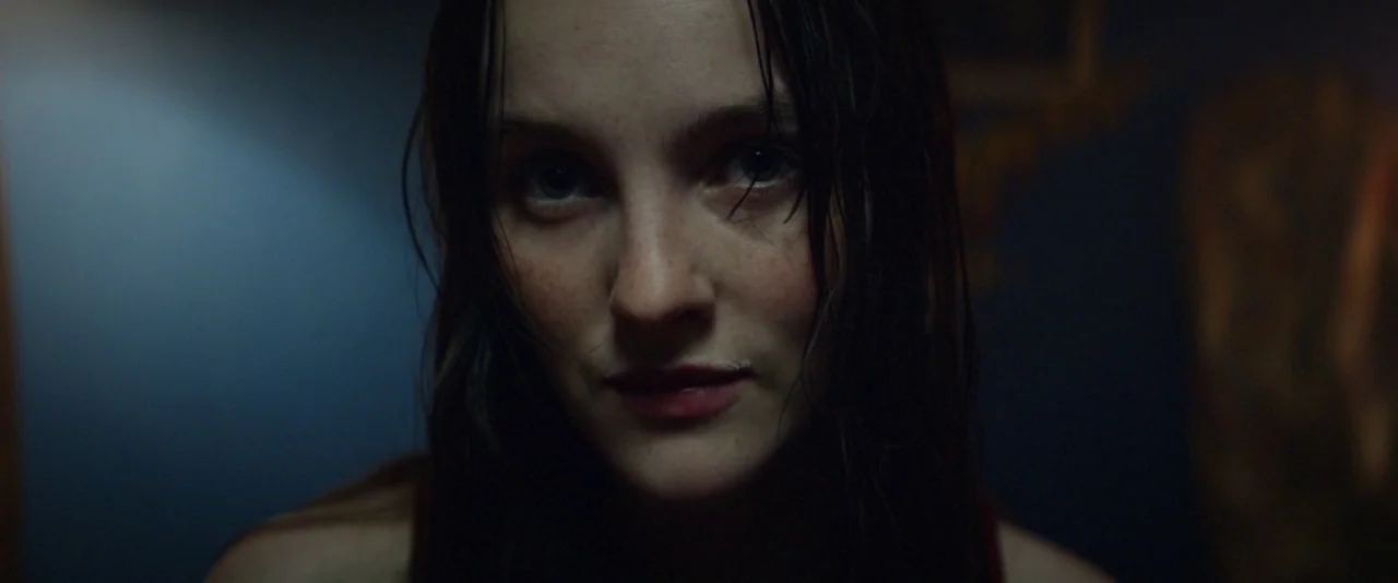 Kissing Candice (2017) movie still: closeup — A dimly lit room provides the setting for a portrait of a young woman. The woman, with wet hair…