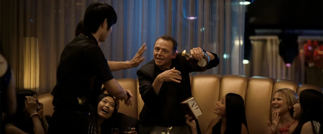 Hector and the Search for Happiness (2014) movie still: medium — A dimly lit lounge features gold-colored curved booth seating and sheer fabric…