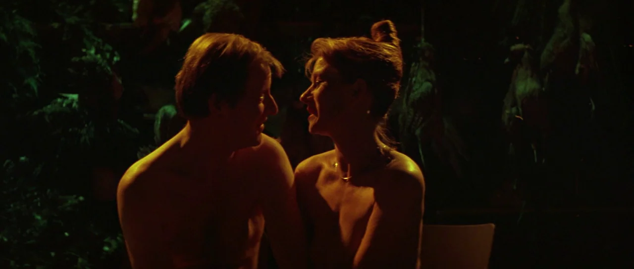 The Cook, The Thief, His Wife & Her Lover (1989) movie still: medium — A dimly lit room with dark surroundings and indistinct foliage in the…