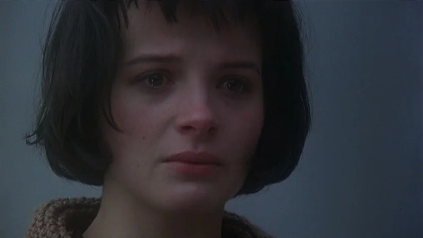 The Unbearable Lightness of Being (1988) movie still: closeup — A woman stands in a dense, grey fog that obscures all distant background details.…