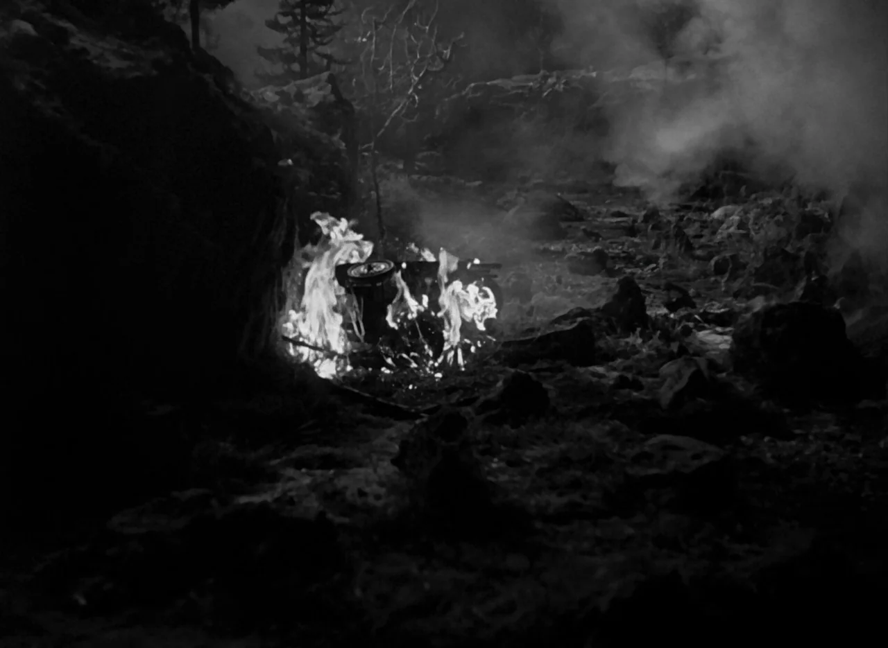 The Invisible Man (1933) (1933) movie still: wide — A dark rocky canyon floor is shrouded in thick smoke and shadow at night. A small piece of…