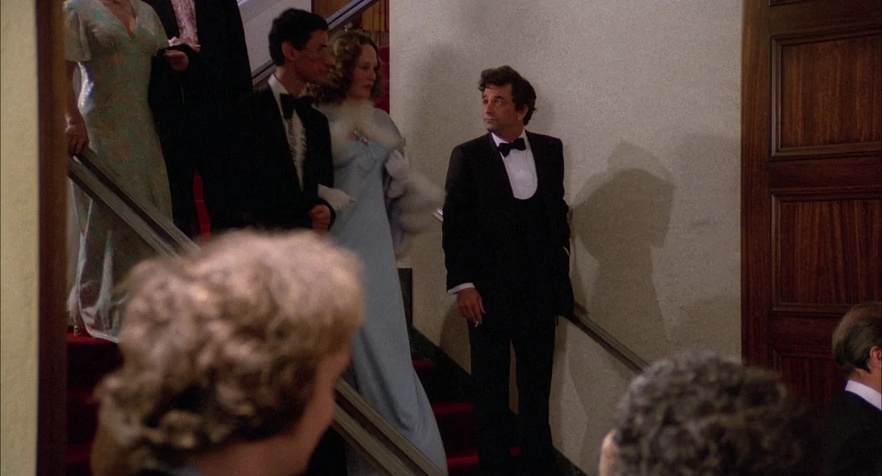 Opening Night (1977) movie still: medium — A grand interior staircase features red carpeting and a plain, light-colored wall surface. A man in…