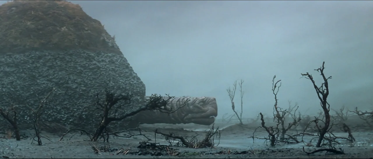 The NeverEnding Story (1984) movie still: wide — A desolate, fog-covered swamp features bare, skeletal trees rising from damp grey mud. A massive,…