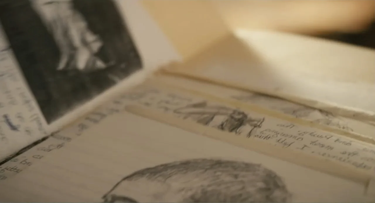 Gates of Darkness (2019) movie still: closeup — An open notebook with lined paper contains handwritten text and graphite illustrations. The page is…