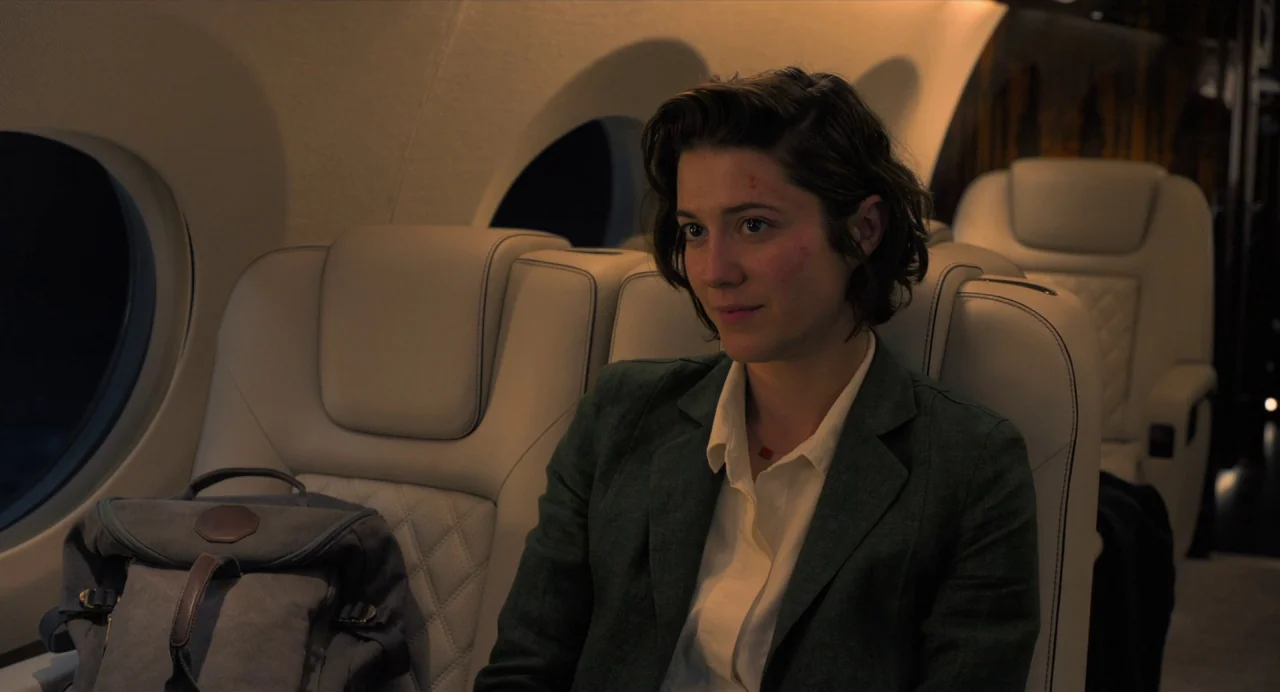 Gemini Man (2019) movie still: medium — A luxury private jet cabin features quilted leather seats and oval-shaped windows at night. A woman in a…