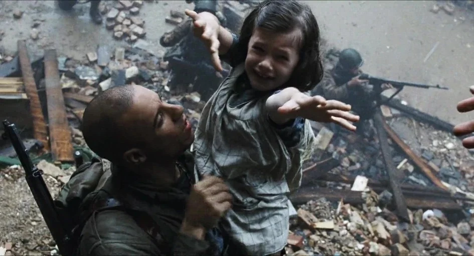Saving Private Ryan (1998) movie still: medium — A pile of debris and broken bricks litters a war-torn urban area. A soldier in military attire…