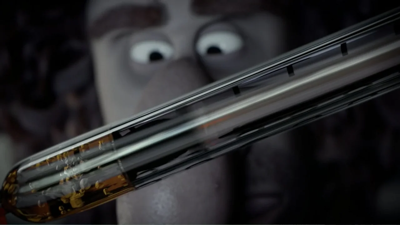 Sausage Party (2016) movie still: closeup — A dimly lit workshop space features a close-up of a glass chemical vial. A stop-motion character stares…