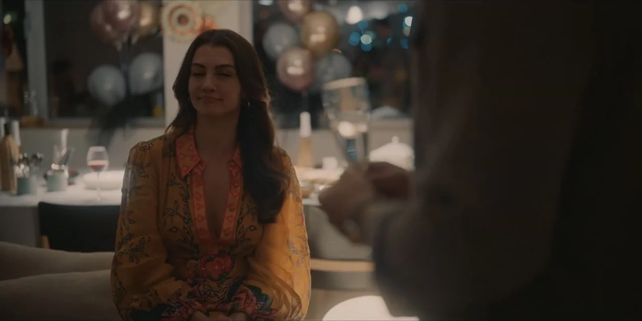 Kill Me If You Dare (2019) movie still: medium — A decorated dining room interior is filled with party balloons and table settings. A woman sits at…