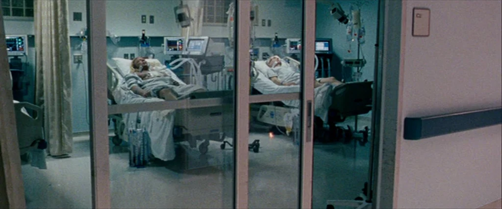 The Wrestler (2008) movie still: wide — An intensive care unit with glass sliding doors separates the hallway from two beds. Each patient is…