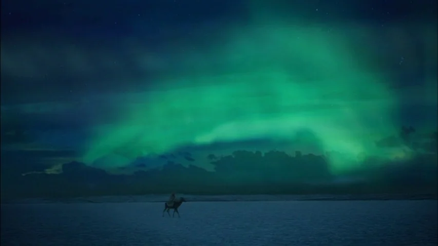 The Sleeping Beauty (2010) movie still: wide — A vast, frozen plain under a dark sky features a prominent aurora borealis display. A small figure on…
