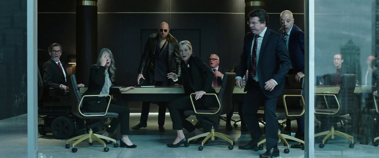 Shazam! (2019) movie still: wide — A dark, modern glass-walled room features a long minimalist table and leather chairs. A group of professionals…