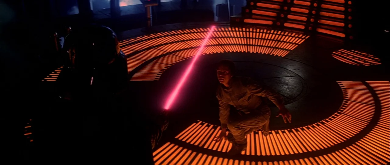 The Empire Strikes Back (1980) movie still: wide — A dark, circular industrial room features glowing orange light emanating from floor-based…