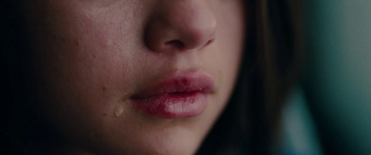 Spring Breakers (2012) movie still: closeup — A close-up of a person's face focusing on the nose and lips. A single clear tear bead travels down the…
