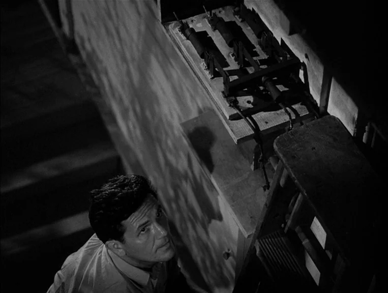 The Postman Always Rings Twice (1946) movie still: medium — A dimly lit basement features a stone wall with a vintage electrical switchboard. A man…