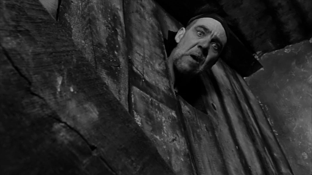 Falstaff (Chimes at Midnight) (1965) movie still: medium — A dark, cramped attic space is constructed of heavy, weathered wooden planks and beams. A…