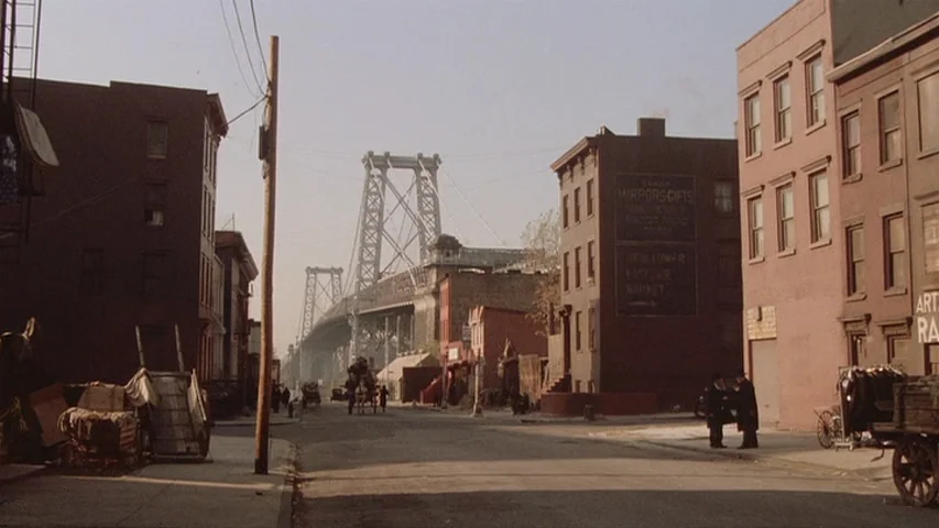Once Upon A Time In America (1984) movie still: establishing — A historic urban street is lined with weathered brick buildings and a large…