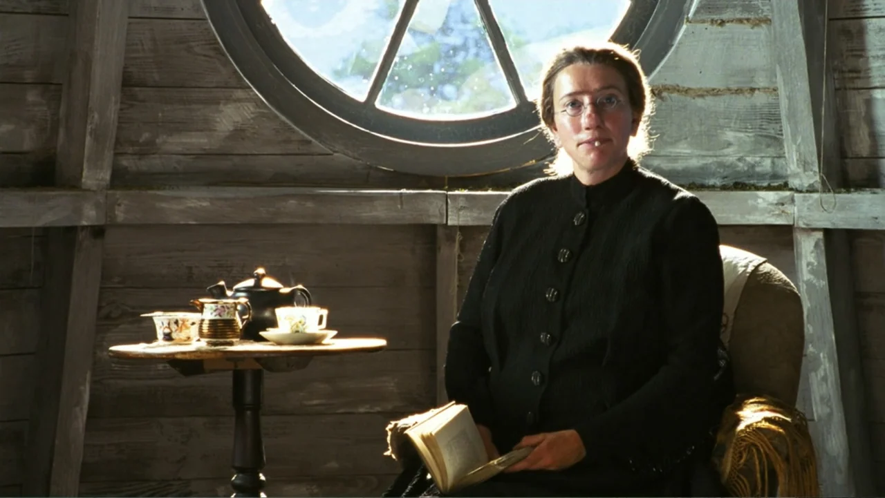 Nanny McPhee and the Big Bang (2010) movie still: medium — An attic room features wooden paneled walls and a prominent circular window. A woman…