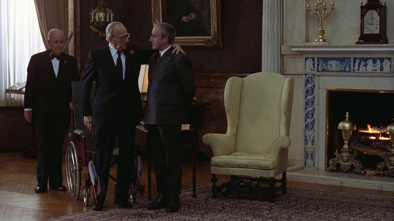 Being There (1979) movie still: fullbody — A formal study featuring mahogany paneling, a large fireplace, and antique furniture. Three men stand…