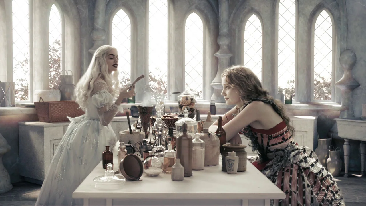 Alice in Wonderland (2010) movie still: medium — A light-filled room with arched windows features a central table covered in antique glassware. Two…